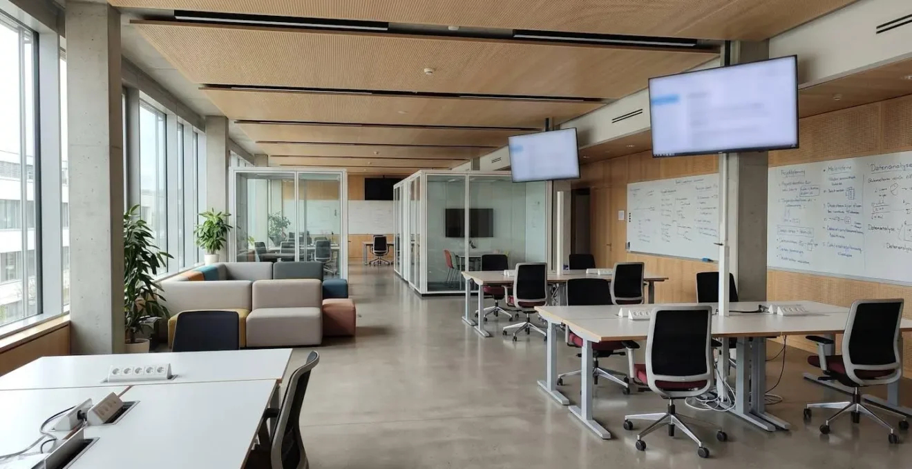 Moderner leerer Co-Working-Space einer Hochschule mit Whiteboards und unscharfen Bildschirmen, helle zeitgenössische Architektur mit grossen Fenstern